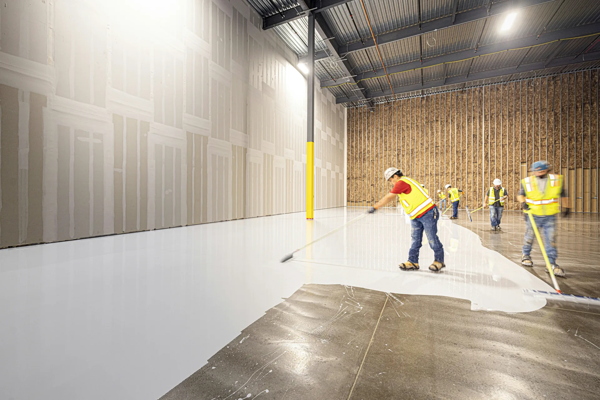 Rust-Oleum coating crew squeegeeing a base coat in Oshawa