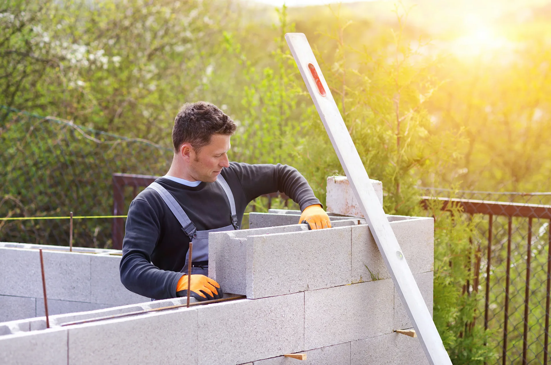 mason levelling a block retaining wall at a Oshawa property