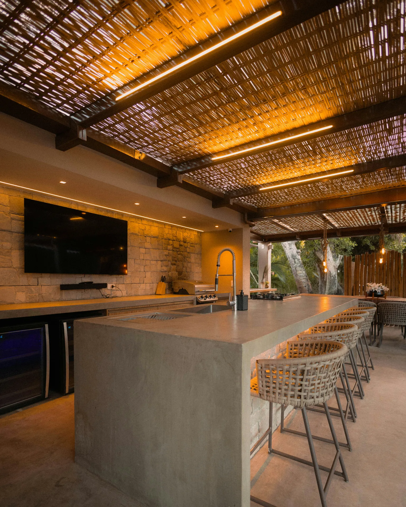 concrete outdoor kitchen bar under a pergola at a Oshawa home